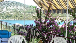 Eine Terrasse mit Tisch und Stühlen mit Blick auf Strand und Meer.