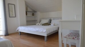Quarto com cama, cadeira e prateleira com objetos decorativos.