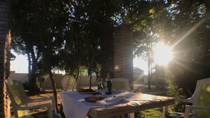 An outdoor dining area with a stone table, white tablecloth, and two wicker chairs. - Strandnahes Haus Lolinka mit schattiger Terrasse by Interhome (Zadar/Bibinje)