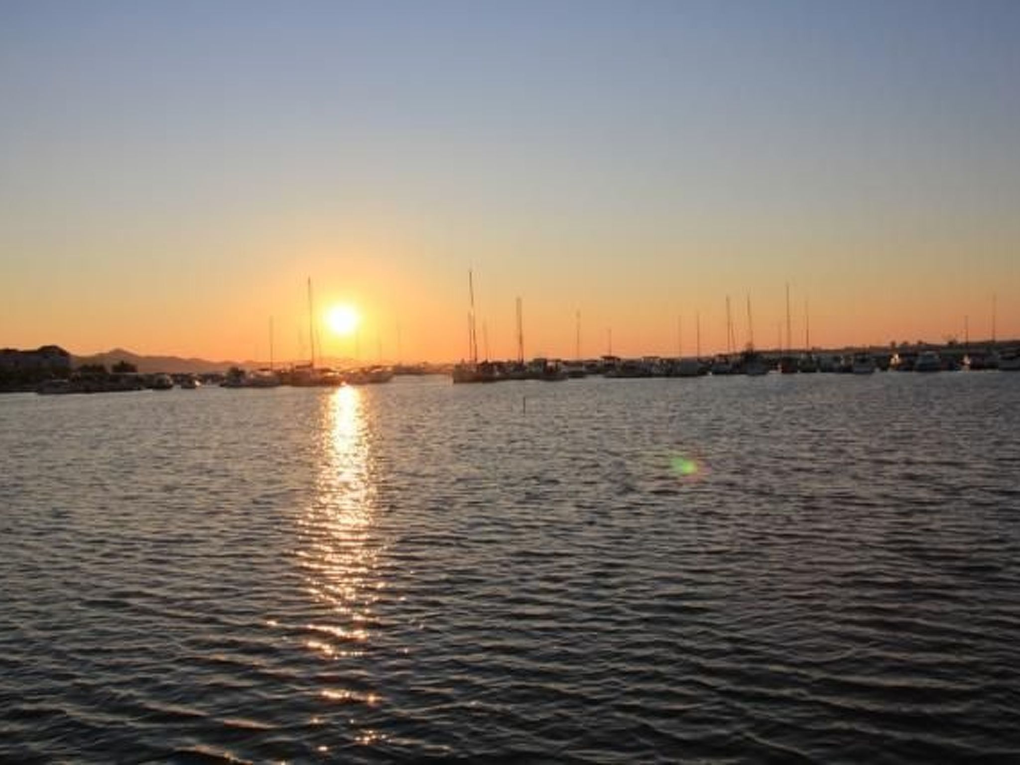 Veneilyasema, jossa veneet ovat ankkuroituina auringonlaskun aikaan.