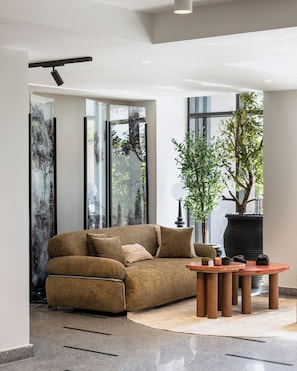 Un salon moderne avec un canapé, une table basse et une plante en pot.