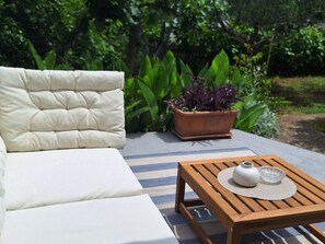 A white cushioned sofa and a wooden table with a white vase and a glass bowl. - Schönes Haus mit privatem Garten by Interhome (Zadar)