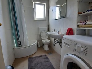 A compact bathroom with a toilet, sink, and washing machine. - Schönes Haus mit privatem Garten by Interhome (Zadar)