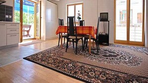 A dining area with a table set for four, a patterned rug, and a view of the outdoors through large sliding doors. - mit Terrasse by Interhome (Zadar)