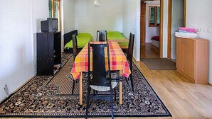 A small, compact room with a dining table, chairs, a sofa, a television, and a wardrobe. - mit Terrasse by Interhome (Zadar)