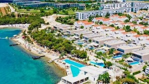 Une station balnéaire comprenant plusieurs bâtiments, une piscine et une plage.