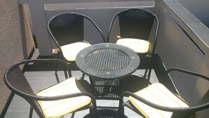 Mesa redonda con cuatro sillas, cada una con un cojín amarillo.
