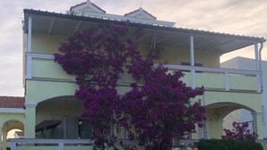 Un edificio de dos pisos con una piscina al frente.