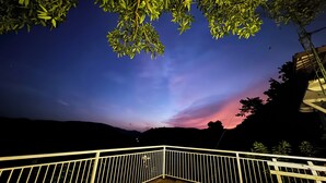 A night scene with a twilight sky, a white metal railing, and a concrete ground. - Wijaya Holiday Resort (Kiriella)