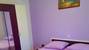 A bedroom with a bed, pillows, a mirror, and a painting on the wall. - Fantastisches Haus nur 700m vom Strand entfernt by Interhome (Rab/Kampor)