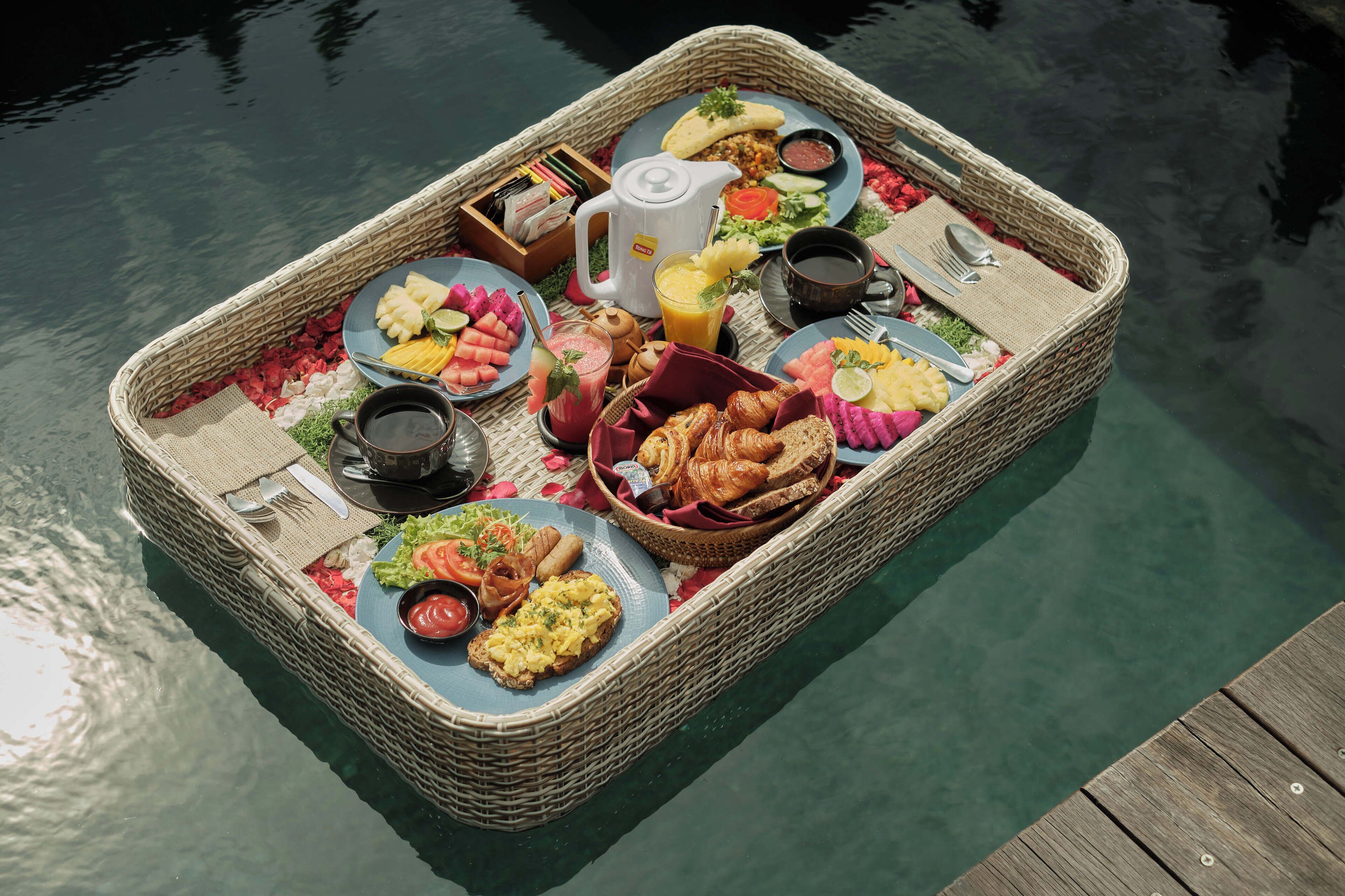 A floating breakfast setup with various dishes, drinks, and utensils.