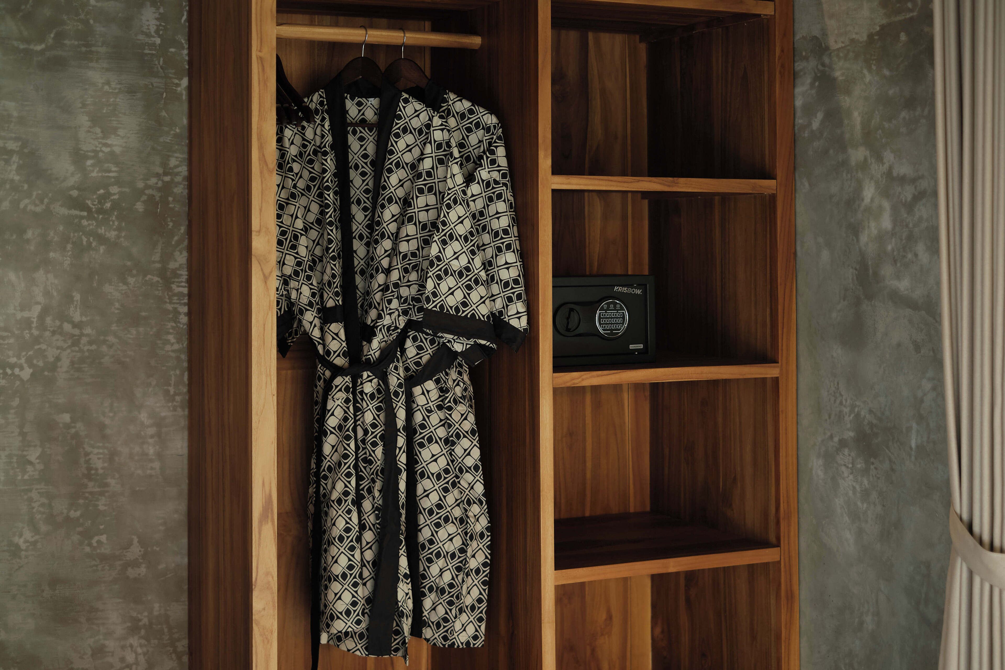 A wooden wardrobe with a radio on the lower shelf.