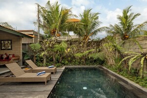Una piscina al aire libre, tumbonas