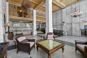A spacious lobby with high ceilings, a glass coffee table, wicker chairs, and a chandelier. - Special/Pool/StepsToBeach/Terrace Studio (Palm Beach)
