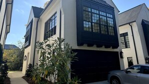 Una casa a due piani con un'ampia porta garage, un'imponente finestra e un piccolo portico.