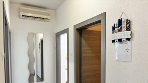 A hallway with a wooden door, a wall-mounted air conditioner, and a welcome sign with a username and password. - in Crikvenica mit Meerblick by Interhome (Crikvenica)