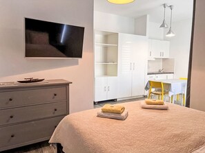 A bedroom with a bed, a TV, a dresser, and a kitchenette. - Wohnung Jasmin 2 by Interhome (Crikvenica)