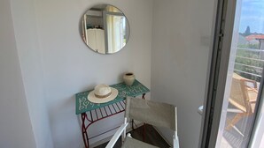A room with a mirror, a small table with a hat, and a chair. - Luxus Ferienhaus AmbraLore by Interhome (Krk/Krk)