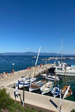 A marina with several boats docked, a clear blue sky, and a distant mountain range. - Wohnung in der Nähe des Meeres by Interhome (Krk/Milohnići)