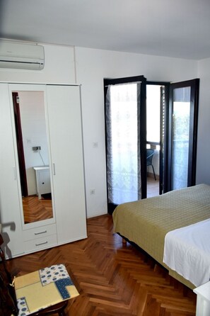 Ein Schlafzimmer mit Bett, Kleiderschrank, Schreibtisch und Stuhl.