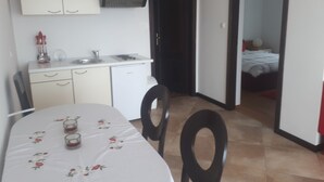Ett kompakt kök med en matplats, ett litet kylskåp och en diskho.