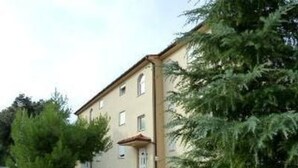 A two-story building with a stone wall and a small porch. - mit Blick auf das Wasser by Interhome (Pula/Banjole)