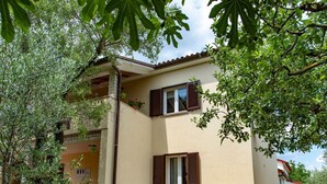 A two-story house with a balcony, a small garden, and a clear sky. - Wohnung a by Interhome (Fažana)