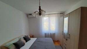 A bedroom with a bed, bedside tables, a wardrobe, and a ceiling fan. - Helle und luftige Ferienwohnung in erster Reihe zum Meer, mit einem privaten Ba by Interhome (Rovinj)