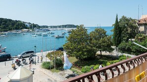 A marina with boats, a parking area, and a view of the sea and hills. - Helle und luftige Ferienwohnung in erster Reihe zum Meer, mit einem privaten Ba by Interhome (Rovinj)