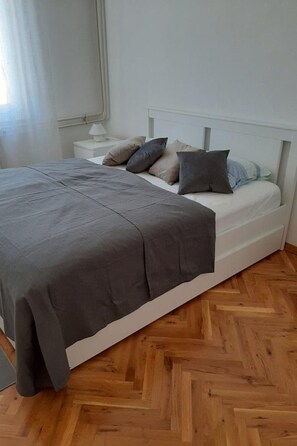 A bedroom with a bed, a nightstand, and a lamp. - Helle und luftige Ferienwohnung in erster Reihe zum Meer, mit einem privaten Ba by Interhome (Rovinj)