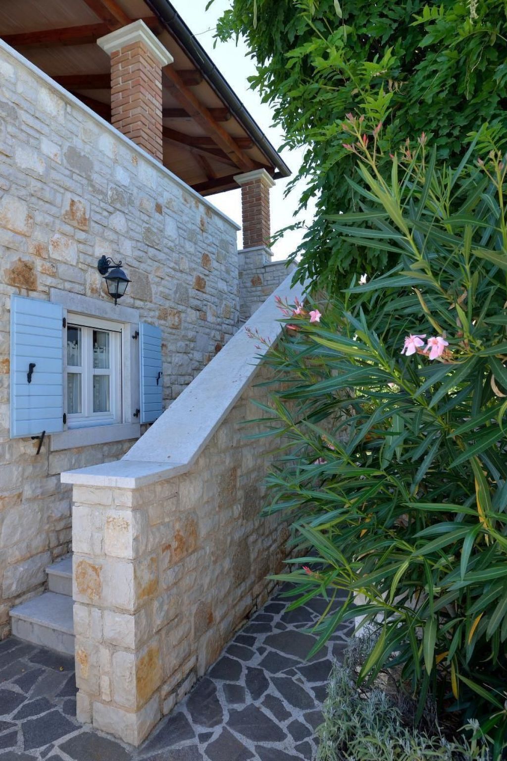 Edifici de pedra amb una escala de pedra que condueix a una terrassa de fusta.