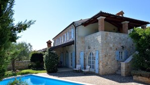 A stone building with a swimming pool, outdoor seating, and a small tower. - Villa Maslinova Grana by Interhome (Poreč/Tar)