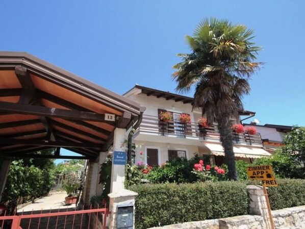 Un edifici amb un balcó, una palmera i un senyal que indica Wi-Fi gratuït.