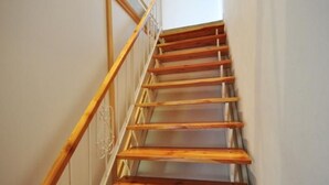 Un escalier en bois, doté d’une rampe, menant à l’étage supérieur.