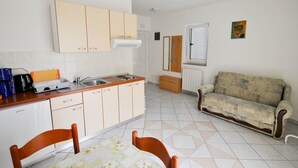 A compact kitchen with a dining area, a sofa, and a radiator. - für 2 Personen 30 m2 in Novigrad, Istrien by Interhome (Novigrad (Istra))