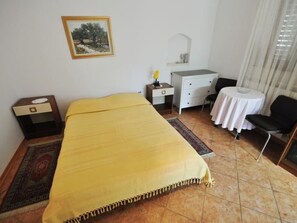 A room with a bed, a desk, a chair, a small table, and a picture on the wall. - in Novigrad mit privatem Parkplatz by Interhome (Novigrad (Istra))