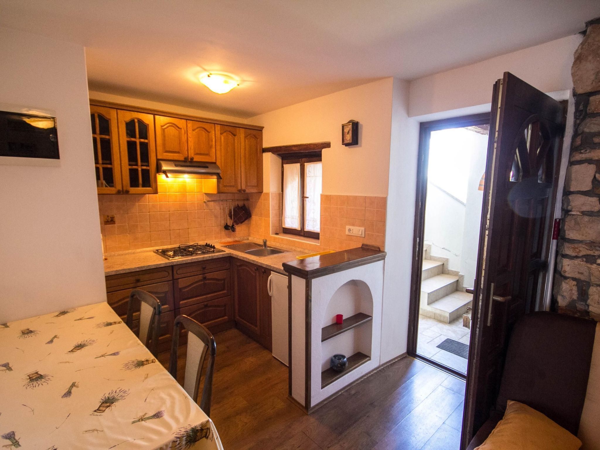 A compact kitchen with wooden cabinets, a gas stove, and a small island.