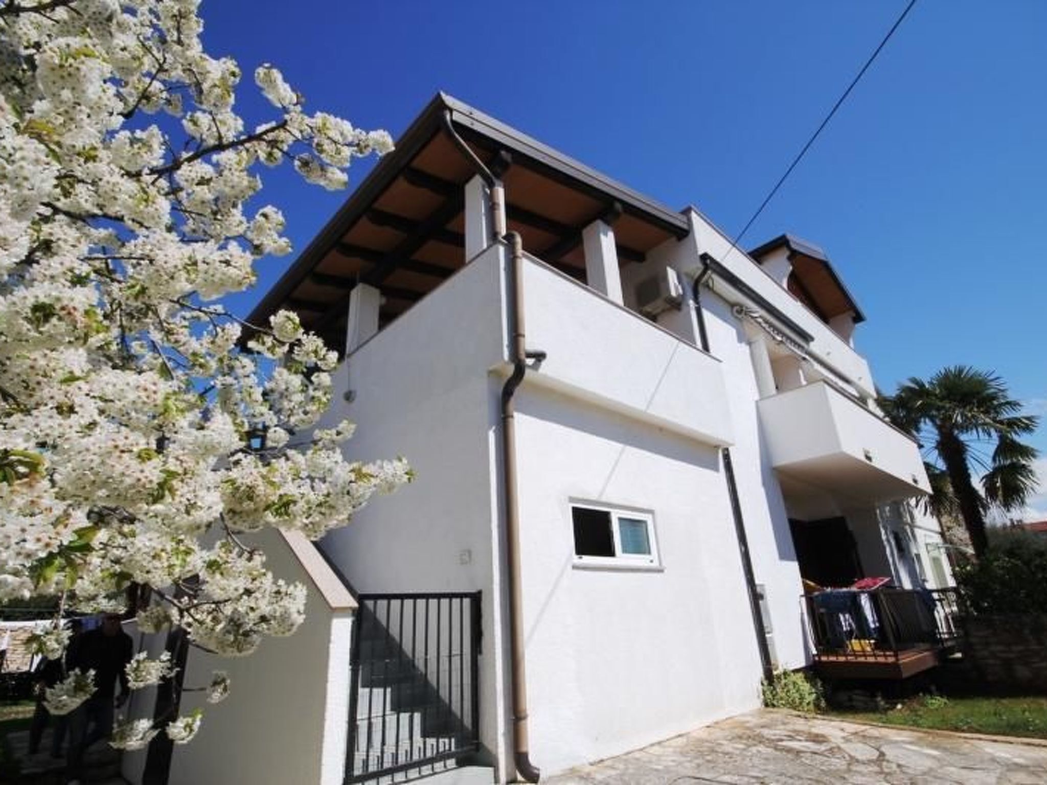 A two-story building with a balcony and a small window.
