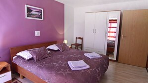 A bedroom with a bed, a wardrobe, a chair, and a nightstand. - Wohnung in Zambratija mit Schöner Terrasse by Interhome (Umag/Zambratija)