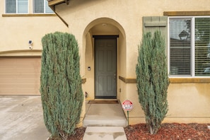 A house with a front door, two evergreen shrubs, a 'No Trespassing' sign, and a garage. - Riverside Insurance Housing/ Furnished 4BR/3BA/ Pets Welcome/ 31+ nights (Riverside)