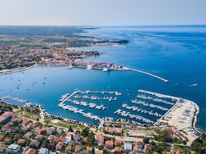 An aerial view of a coastal marina with multiple docks and boats, surrounded by residential buildings and a clear view of the sea. - Martina B4 by Interhome (Umag)
