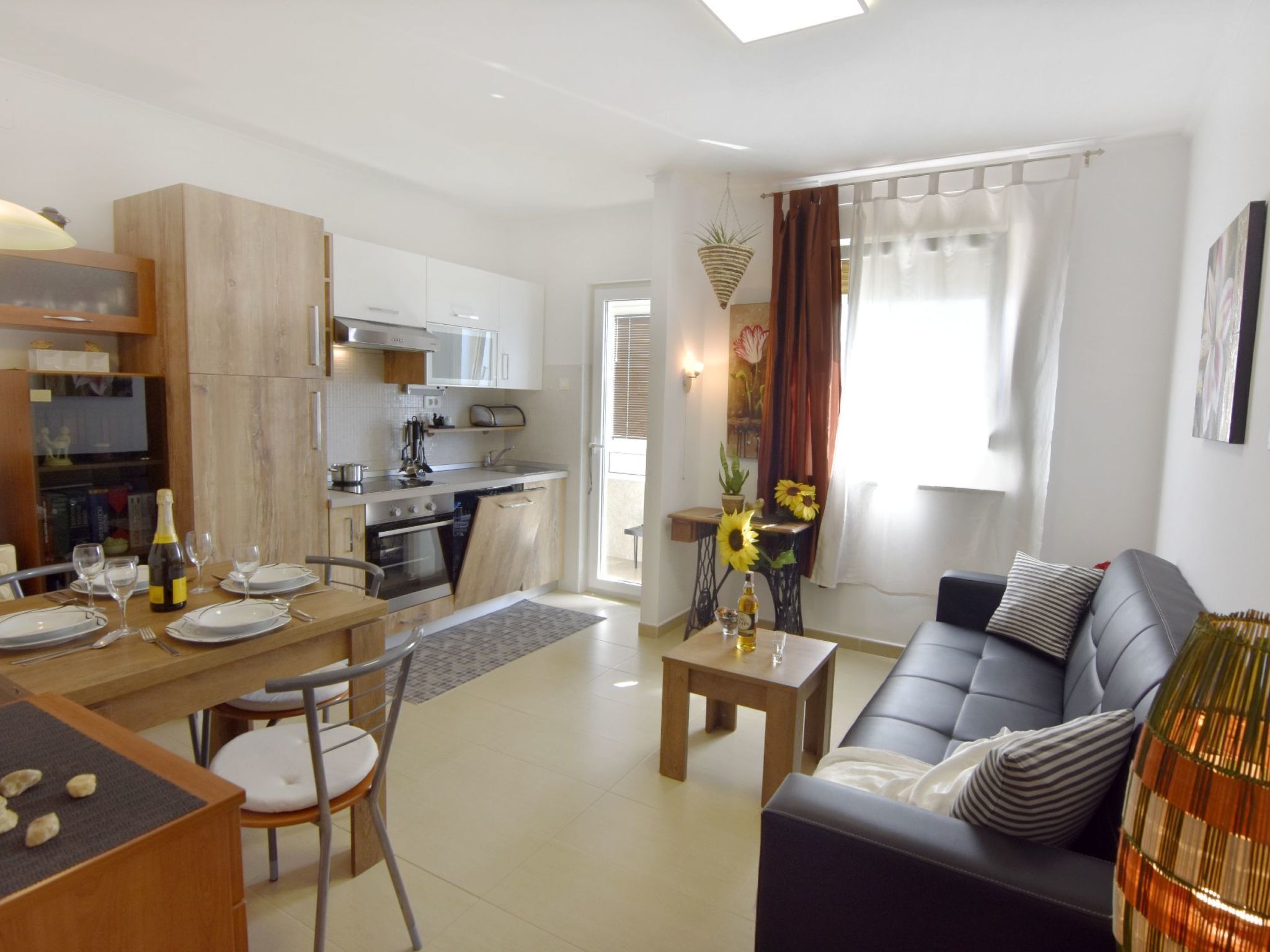 A modern apartment with a kitchen, dining area, and living room.