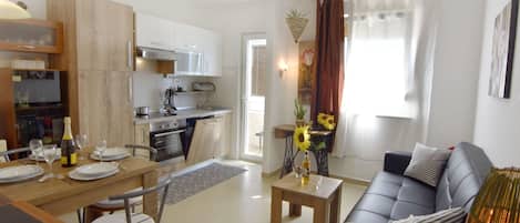 A modern apartment with a kitchen, dining area, and living room.