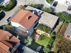 An aerial view of a residential area with multiple houses, each featuring red-tiled roofs and surrounded by greenery. - LINO B4 by Interhome (Umag)