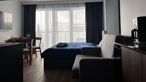 A modern hotel room with a bed, a desk, a chair, a coffee machine, and a TV. - Apartment Sky by Interhome (Kolobrzeg)