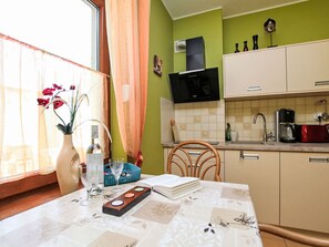 A kitchen with a microwave, a coffee maker, and a red toaster.