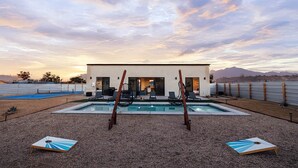 Ein modernes Haus mit Pool, Außenbereich und Blick auf Berge.