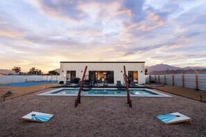 Ein modernes Haus mit Pool, Außenbereich und Blick auf Berge.