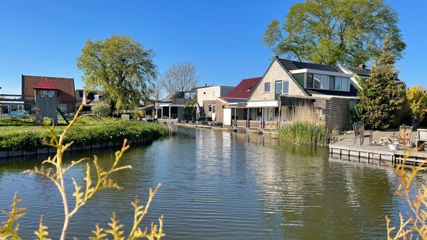 A canal with houses on one side and a playground on the other. - Haus Jeff by Interhome (Wervershoof)