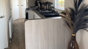 A modern kitchen with light wood cabinetry, a central island, and a view to the outside. - Haus Jeff by Interhome (Wervershoof)